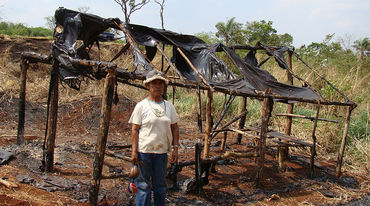 Um Guarani-Kaiowá à frente da sua casa