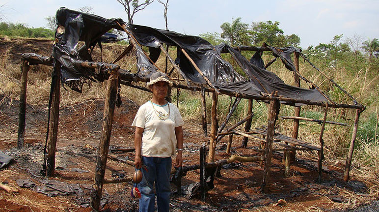 Um Guarani-Kaiowá à frente da sua casa