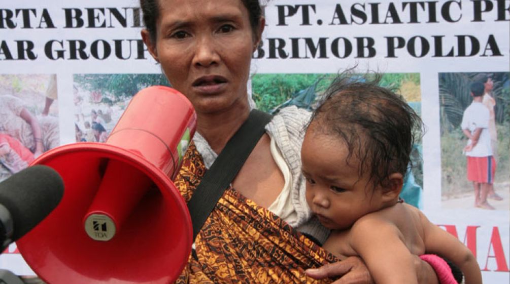 Uma manifestante com o seu bebê e um megafone na mão